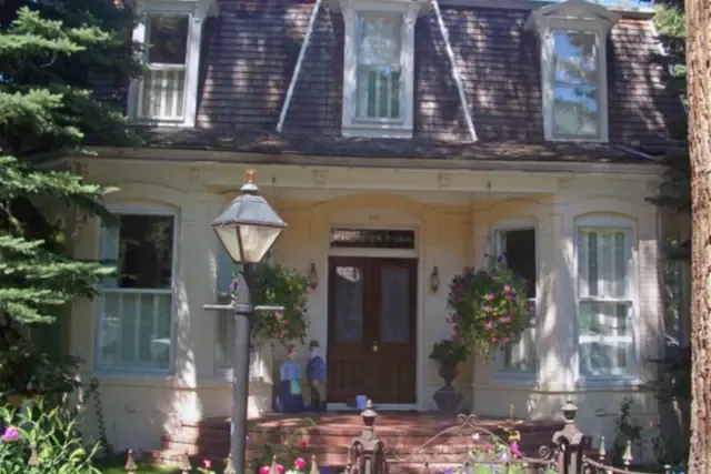 Restored Victorian house with a front porch and flowers in Aspen's West End
