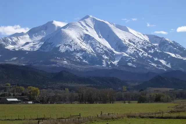 Snow-covered Mount Sopris rising above pasture and cottonwoods near Carbondale