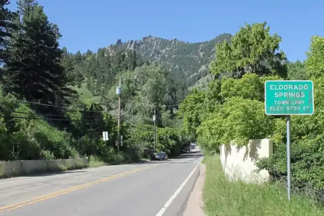 Eldorado Springs Drive leading into the canyon past green trees and sandstone cliffs