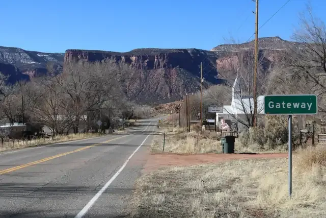 Highway 141 entering Gateway below red sandstone cliffs