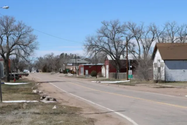 A quiet road through Grover with cottonwoods and older buildings