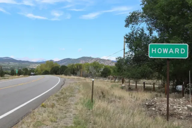 US 50 curving through Howard with the Sangre de Cristo foothills behind