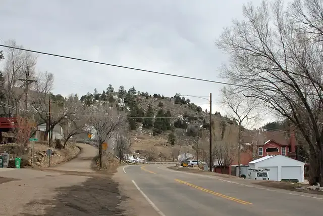 Highway 74 curving through Idledale with homes on the canyon slope