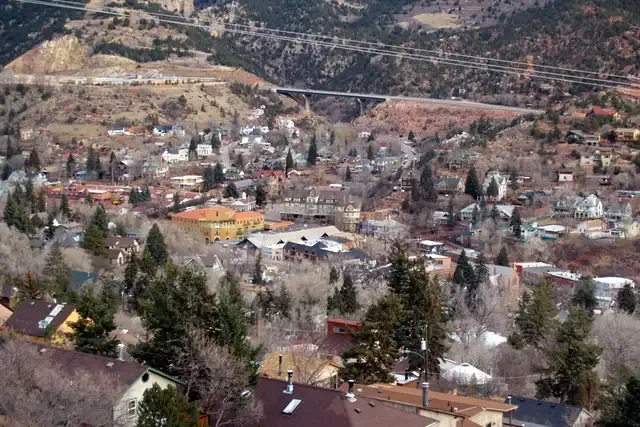 Victorian cottages on a steep wooded street in Manitou Springs below the mountains