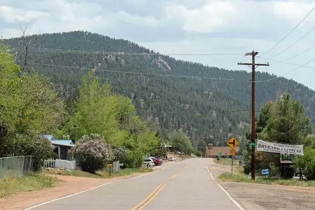 County Road 126 through Pine with houses, trees and forested hills