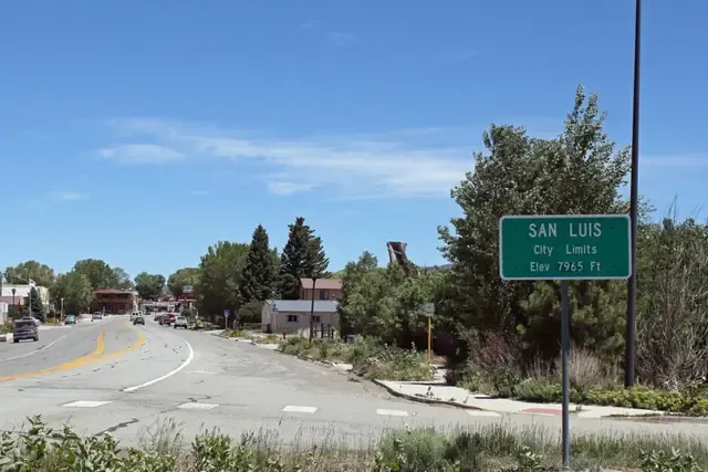 Highway 159 entering San Luis past cottonwoods and adobe buildings