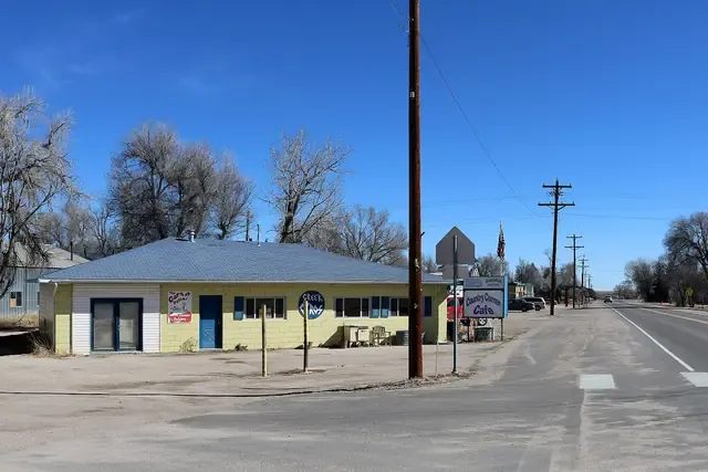 US 24 through Simla with a small shop, cottonwoods and wide prairie sky