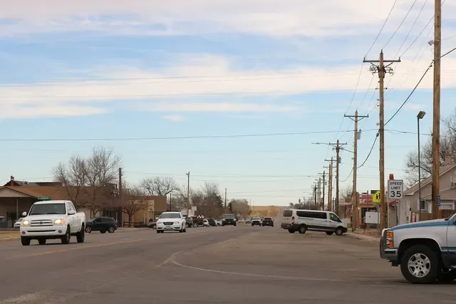 Quiet main road through Strasburg with low homes and bare trees on the plains