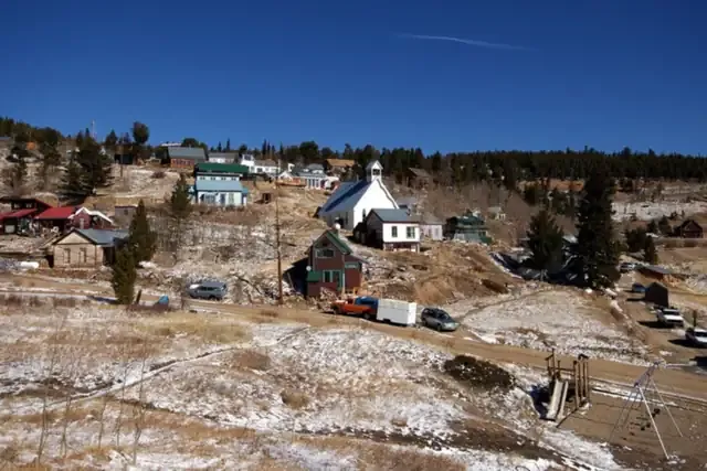 Overview of Ward's cabins, church and homes on a snowy mountainside